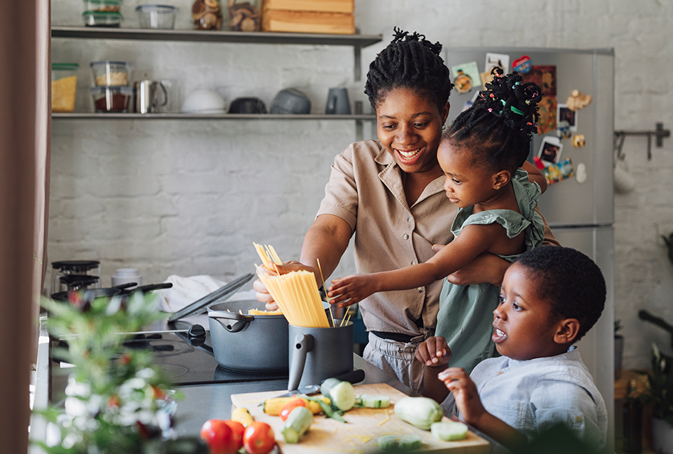Mother with her two children cooking dinner
